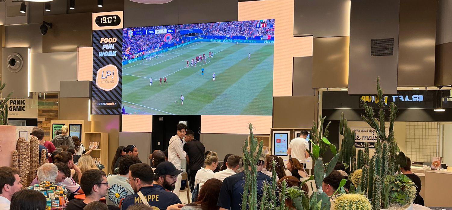 Le foodcourt et son écran géant, diffusant un match de foot